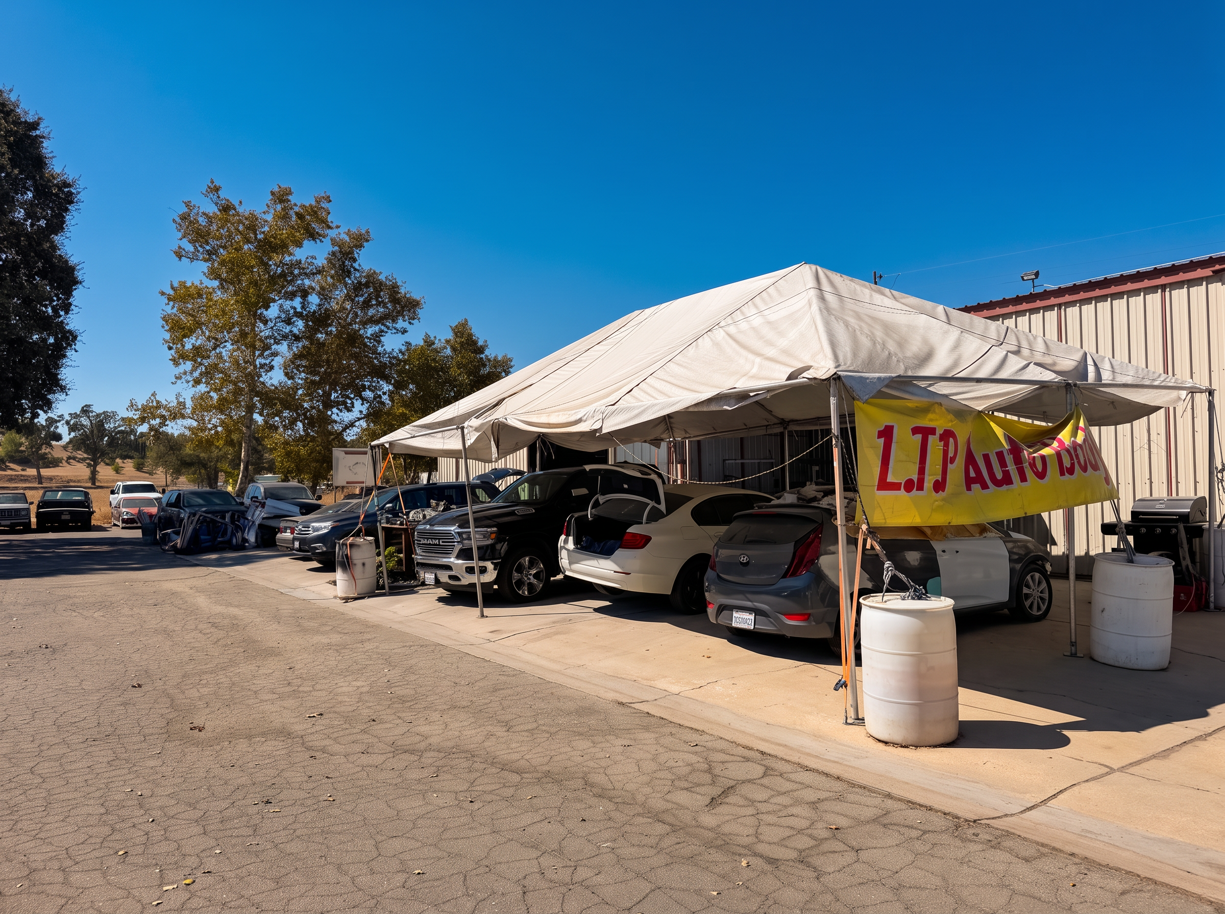 Cars under the LTP Auto Body work tent in Paso Robles